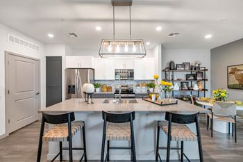 A kitchen with a large island with four stools